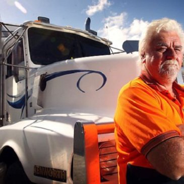 orange T-shirt man is standing in front of a truck